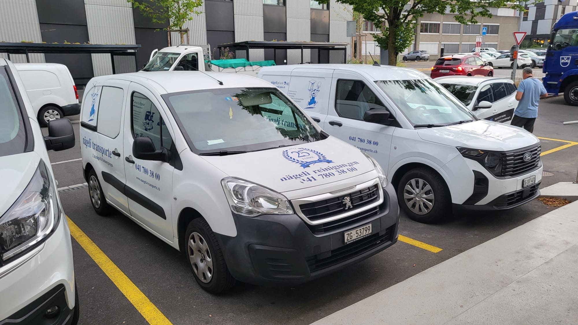 Zwei Firmenvans von nägeli auf einem Parkplatz
